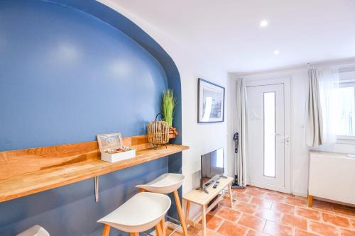 - un salon avec un mur bleu et des tabourets dans l'établissement Le Panier - Appart proche Vieux-Port, à Marseille