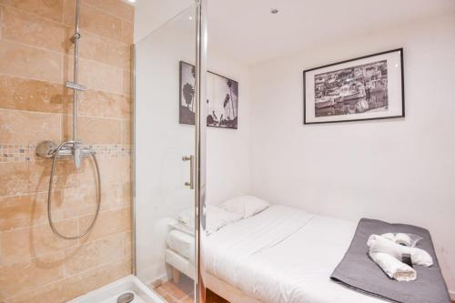 une petite salle de bain avec douche et un lit dans l'établissement Le Panier - Appart proche Vieux-Port, à Marseille