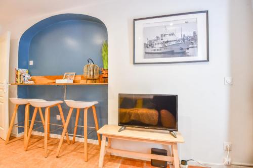 - un salon avec une cheminée et un bar avec des tabourets dans l'établissement Le Panier - Appart proche Vieux-Port, à Marseille