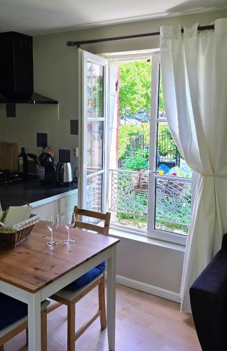 une cuisine avec une table et une fenêtre avec des verres à vin dans l'établissement La Maison du Tourniquet, à Aubeterre-sur-Dronne