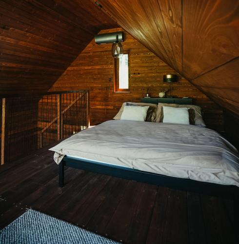 a bedroom with a bed in a wooden cabin at Živili in Smilkov