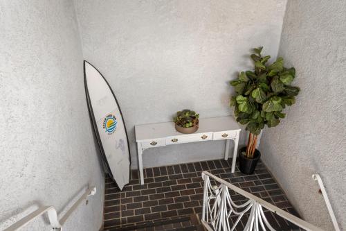 a room with a surfboard and a table with a plant at Ocean Park Inn in Los Angeles