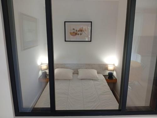 un reflet miroir d'un lit dans une pièce dans l'établissement Appart à deux pas de la plage Boulouris St Raphael, à Saint-Raphaël
