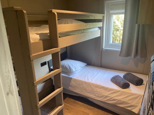 ein Etagenbett in einem Schlafzimmer mit einem Etagenbett in der Unterkunft Chalet VIP Ostéa au coeur du Bassin d'Arcachon in La Teste-de-Buch