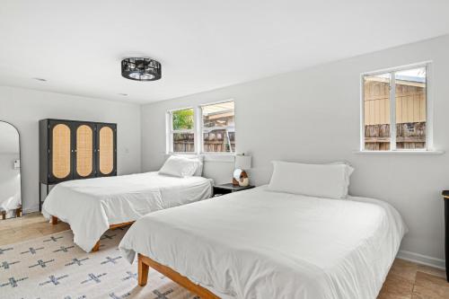 two beds in a room with two windows at Poolside Getaway, Close To Dt Coastal Beach in West Palm Beach