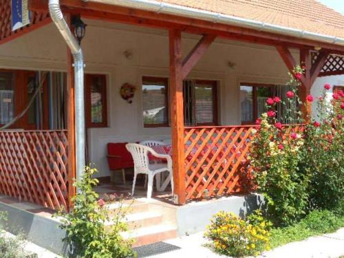 a porch of a house with a table and chairs at Rózsakert Apartman 2 in Poroszló