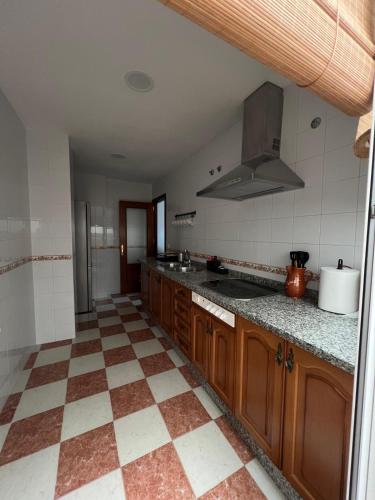a kitchen with wooden cabinets and a tiled floor at Apartamento Relax Centro in Sanlúcar de Barrameda