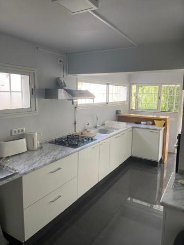 a kitchen with white cabinets and a stove top oven at Loft in Carthage in Carthage