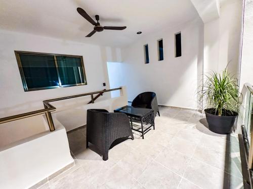 a living room with a ceiling fan and a table at San Carlos Valladolid in Valladolid