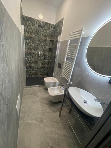 a bathroom with two toilets and a sink and a mirror at La casa della stazione in La Spezia