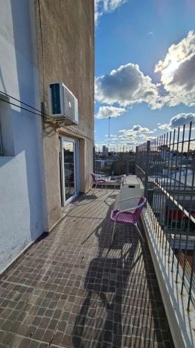 a balcony with a purple bench on a building at Santa Rosa Hotel in Olavarría