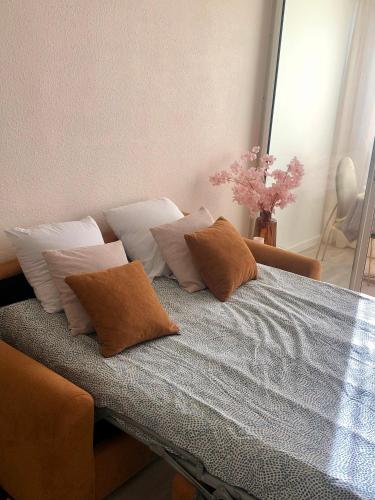 - un lit avec plusieurs oreillers dans l'établissement Studio L envie d ailleurs, à Marseillan