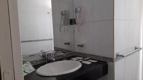 a bathroom with a toilet and a sink and a phone at Santa Rosa Hotel in Olavarría