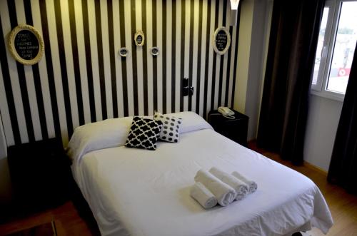 a bedroom with a white bed with towels on it at Santa Rosa Hotel in Olavarría