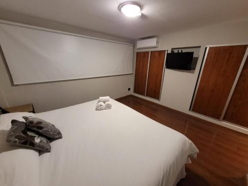 a bedroom with a white bed with two towels on it at Santa Rosa Hotel in Olavarría