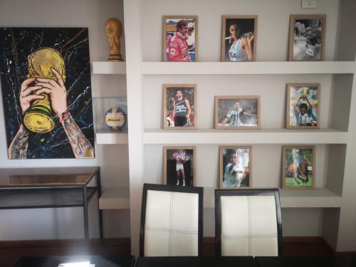 a wall with a bunch of pictures on it at Santa Rosa Hotel in Olavarría