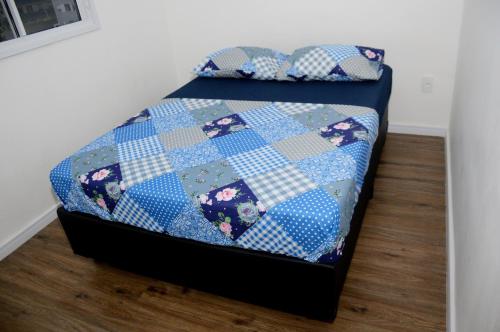 a bed with a quilt on top of it at Apartamento aconchegante no bairro Liberdade in Sao Paulo