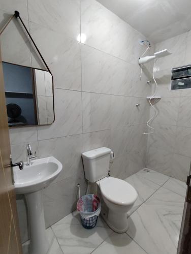 a bathroom with a toilet and a sink and a mirror at Casa Mineira - Flats novos em Ponta de Mangue - Maragogi in Maragogi