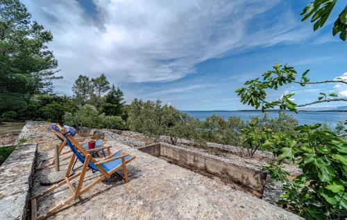 a blue bench sitting on top of a stone wall at 2 Bedroom Amazing Home In Vela Luka in Vela Luka