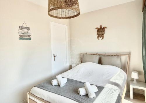 une chambre avec un lit avec des draps blancs et des oreillers dans l'établissement Appartement Mer & Soleil, à Le Touquet-Paris-Plage