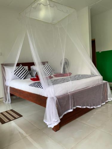 a bed with a mosquito net in a room at Liana Guest House Ella in Ella