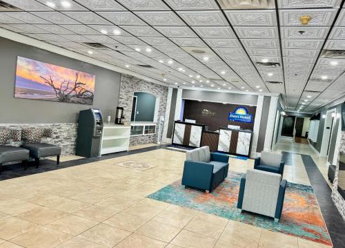 a lobby with a waiting room with chairs and a television at Days Hotel by Wyndham Williamsburg I-64 in Williamsburg