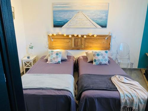two twin beds in a room with a picture on the wall at Appartement 74 cita Di sali in Porto-Vecchio
