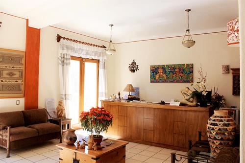 a living room with a couch and a table at Hotel Dainzu in Oaxaca City