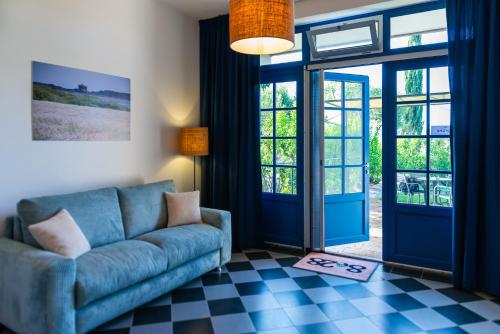 a living room with a blue couch and glass doors at AGRITURISMO 8e28 CAPALBIO in Nunziatella