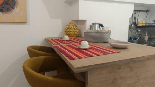 Una mesa de cocina con una mesa de madera con dos sillas. en Casetta Anna Maria, en Fasano
