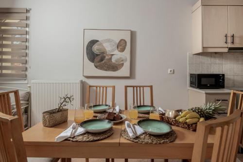 a dining room table with plates and bowls on it at Alavastros Villa Maisonettes in Vasilikos