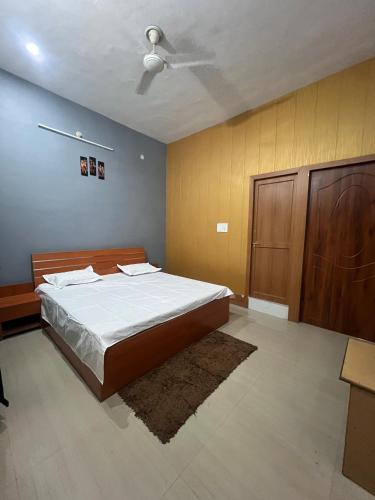 a bedroom with a bed and a ceiling fan at Shri Shyam Kunj in Ayodhya