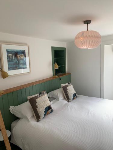 a bedroom with two beds and a pendant light at Squirrel Away At Leven House in Crieff