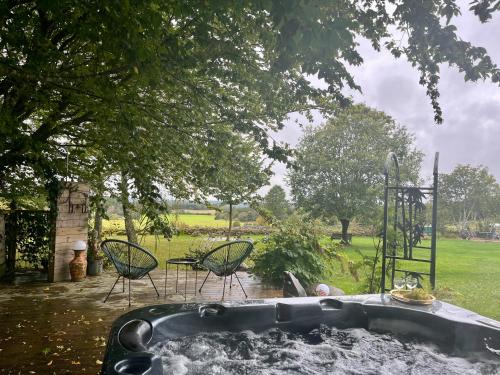 a hot tub in a yard with chairs and a park at Naturnära Fritidsboende, Trollebo - YinTorp in Arkelstorp