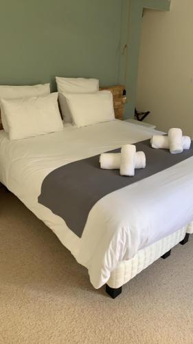 a large white bed with white pillows on it at Le Tronçais in Saint-Bonnet-Tronçais