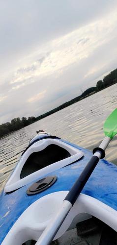a blue and white kayak with a paddle on the water at Zew Natury in Skorka