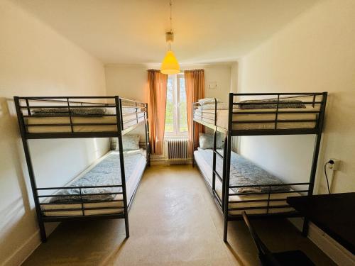 three bunk beds in a room with a window at Hässlebogården Turist & Konferens in Mariannelund
