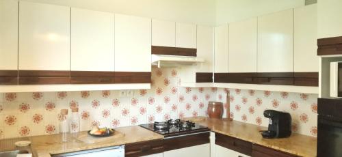 a kitchen with white cabinets and a stove at Family home Cour du Louvre in Saint-Sever-Calvados