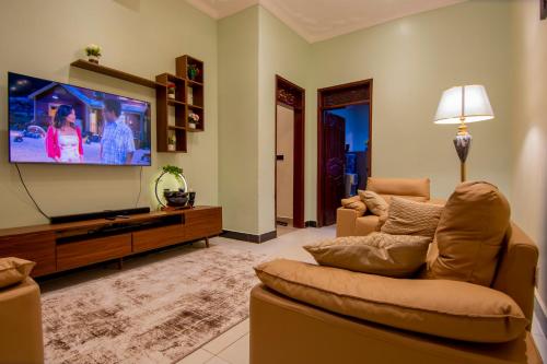 a living room with a couch and a flat screen tv at Urban Oasis located at Kyebando Nsooba in Kyebando