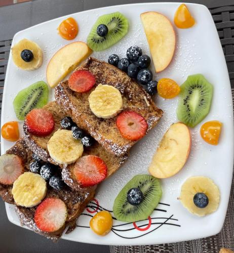 a plate of french toast with fruit on it at CoLinkHouse Hotel in Medellín