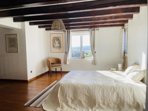 une chambre avec un grand lit et une fenêtre dans l'établissement Maison Malliague avec piscine chauffée, à Barjac