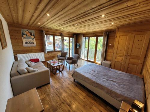 un salon avec un grand lit et un canapé dans l'établissement Appartement cosy, 3 balcons, plein centre, proche pistes - idéal 5-6 pers. - FR-1-598-101, aux Gets