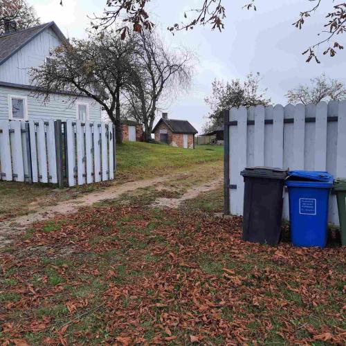 two trash cans next to a white fence at Sodyba Po liepom in Krikštonys