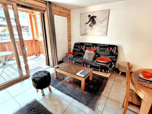 un salon avec un canapé et une table dans l'établissement Appartement 3* au centre des Gets, avec balcon-terrasse, Wifi, et garage - FR-1-598-137, aux Gets