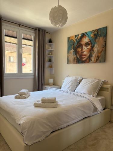 Un dormitorio con una gran cama blanca con toallas. en Elegant Apartment Terrace Port of Nice, en Niza