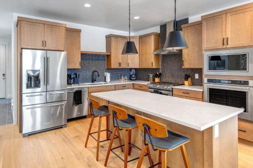 a kitchen with wooden cabinets and a large island with bar stools at Silver Creek Village 6635 in Park City
