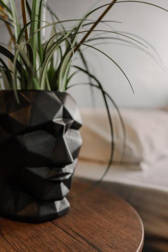 a black vase sitting on a table with a plant at Arkadia Beach Hotel in Odesa