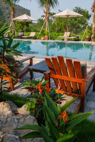 a couple of chairs sitting next to a swimming pool at Tam Coc Peaceful Nature in Vũ Lâm