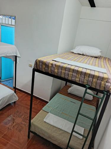 2 letti a castello in una piccola camera con finestra di Hostal EL TRIUNFO MUKUPETRA a San Agustín