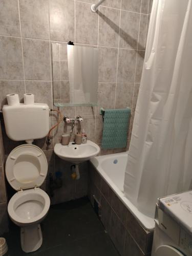 une salle de bains avec toilettes, lavabo et baignoire dans l'établissement Coastal View Apartment, à Bar